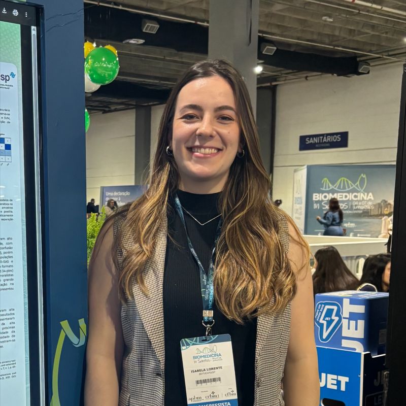 Isabela next to her e-poster at Biomedicina in Santos.